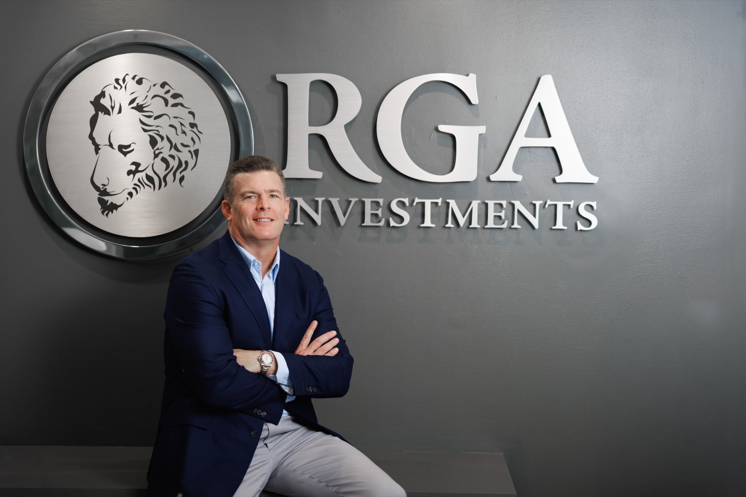 Rick Gardner in front of the RGA Investments logo