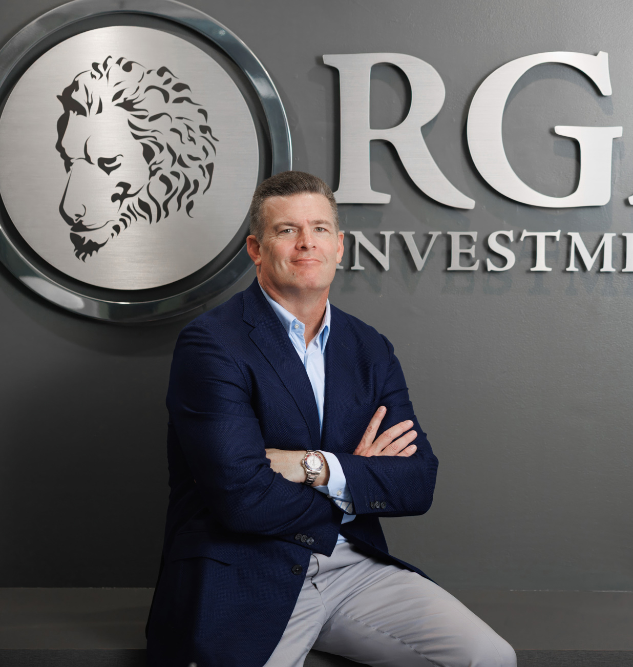 Rick Gardner seated in front of the RGA Investments sign